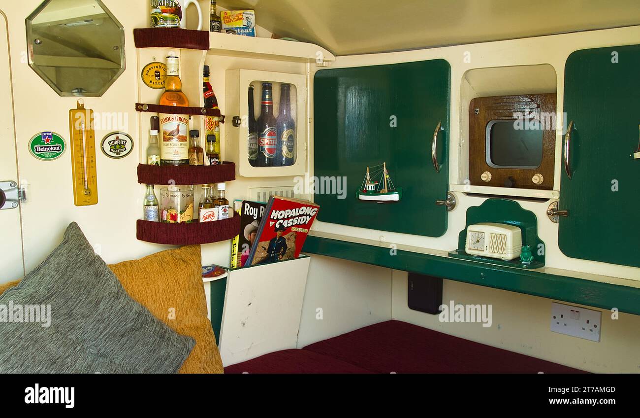Interno, all'interno di Un caravan degli anni '1960 con bevande, Period Comics e Old Phillips Television, Christchurch UK Foto Stock