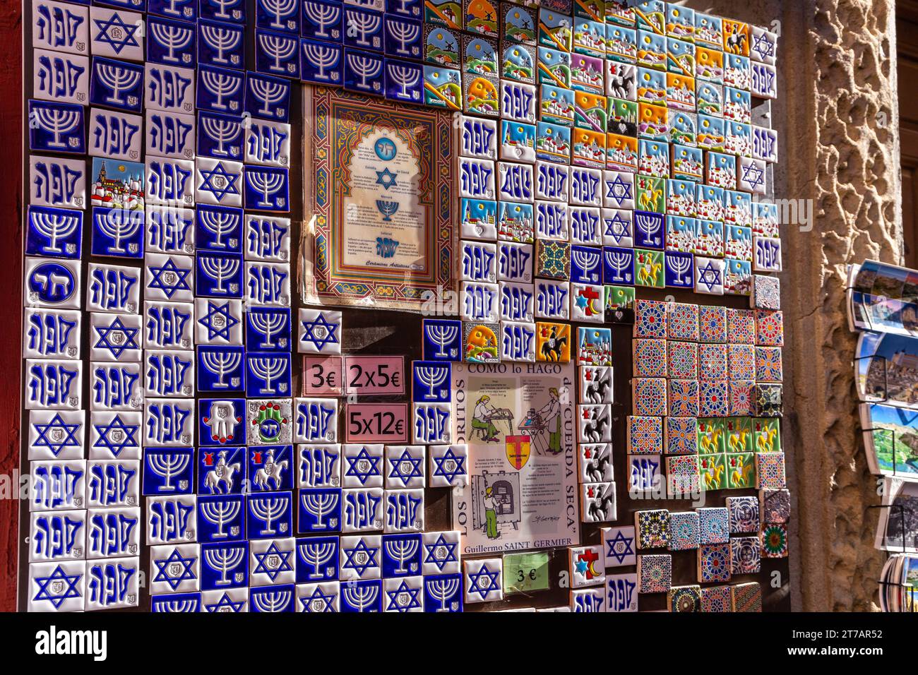 Toledo, Spagna, 08.10.21. Mostra di souvenir con colorate piastrelle magnetiche del frigorifero con simboli ebraici: menorah, Stella di Davide e simbolo della rete Foto Stock