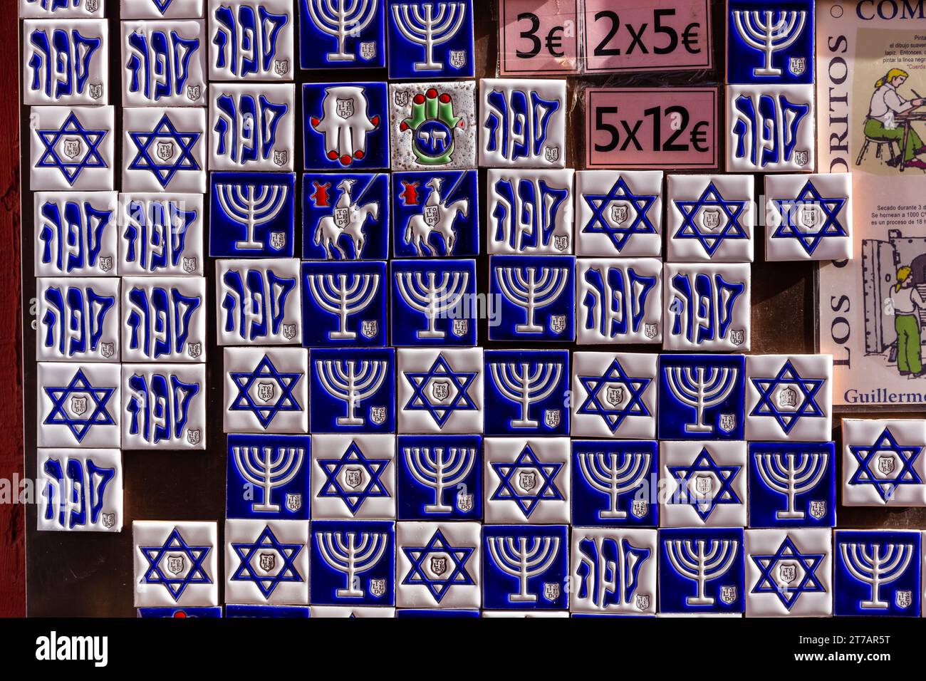 Toledo, Spagna, 08.10.21. Mostra di souvenir con piastrelle magnetiche bianche e blu con simboli ebraici: menorah, Stella di Davide e simbolo della N Foto Stock