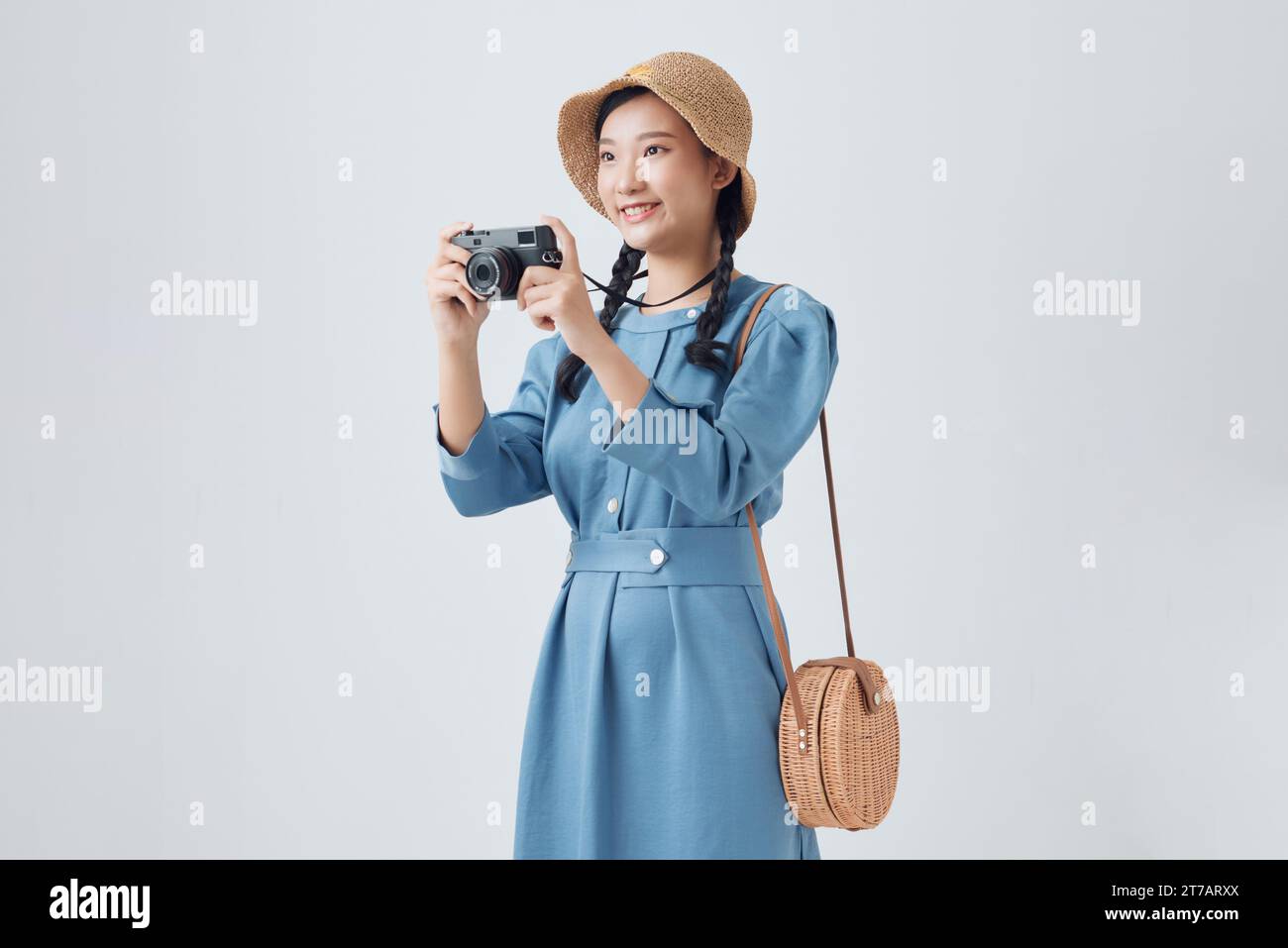 Bella ragazza con una vecchia fotocamera su sfondo bianco Foto Stock