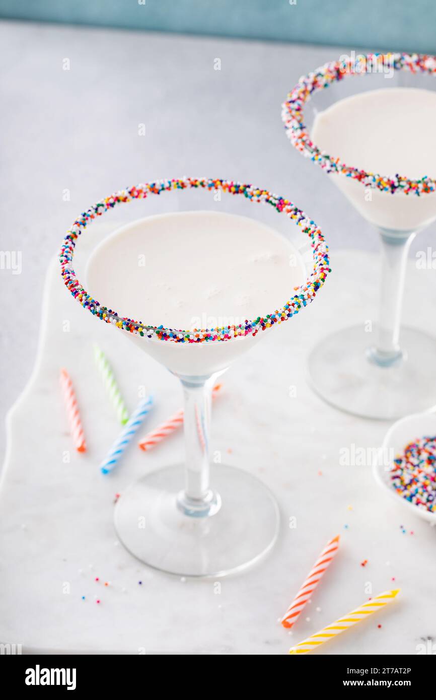 Torta di compleanno dolce e cremoso martini con spolverini sul bordo, divertente idea di cocktail Foto Stock