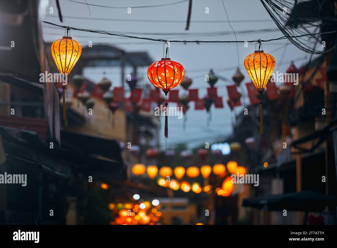 Lanterne tradizionali appese sulla vecchia strada di Hoi An in Vietnam. Vita notturna nella città antica. Foto Stock