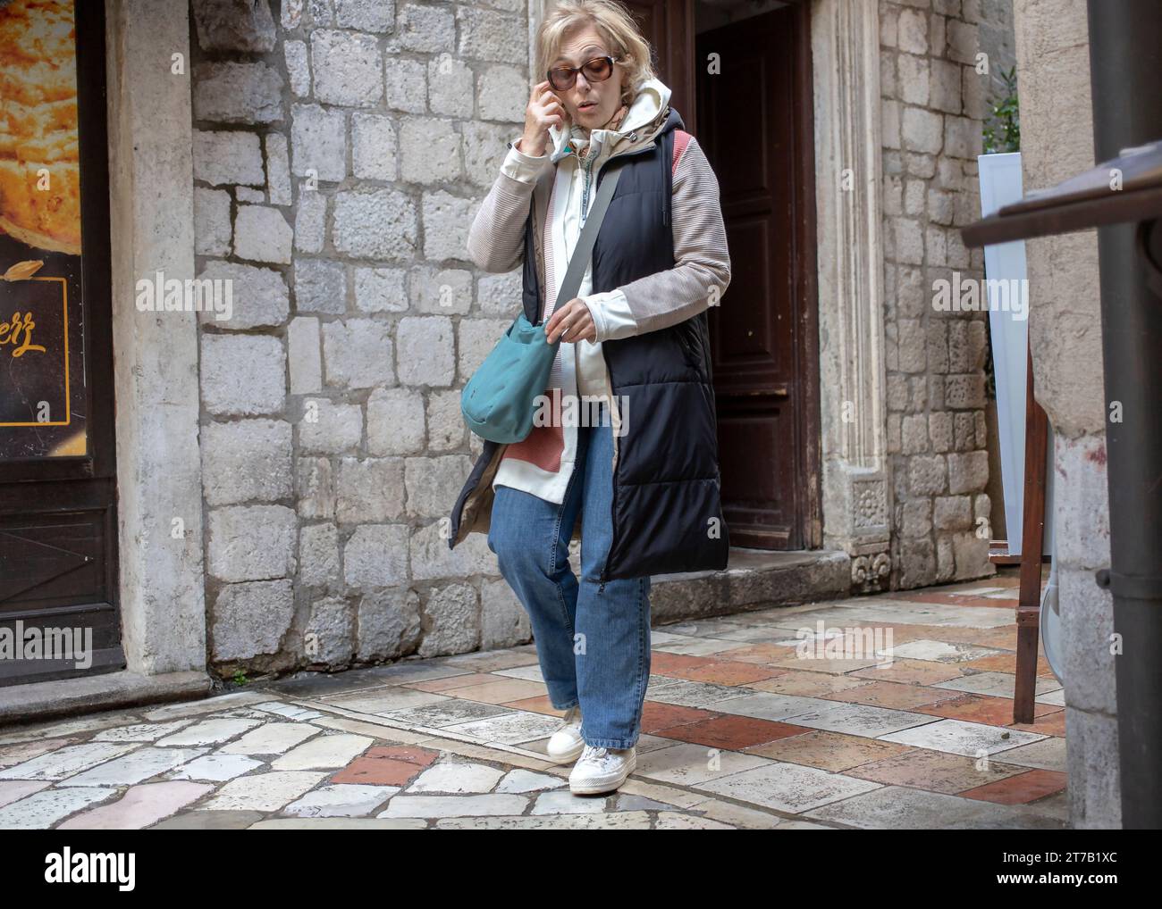 Kotor, Montenegro, 15 aprile 2023: Donna che cammina lungo la strada della città vecchia Foto Stock