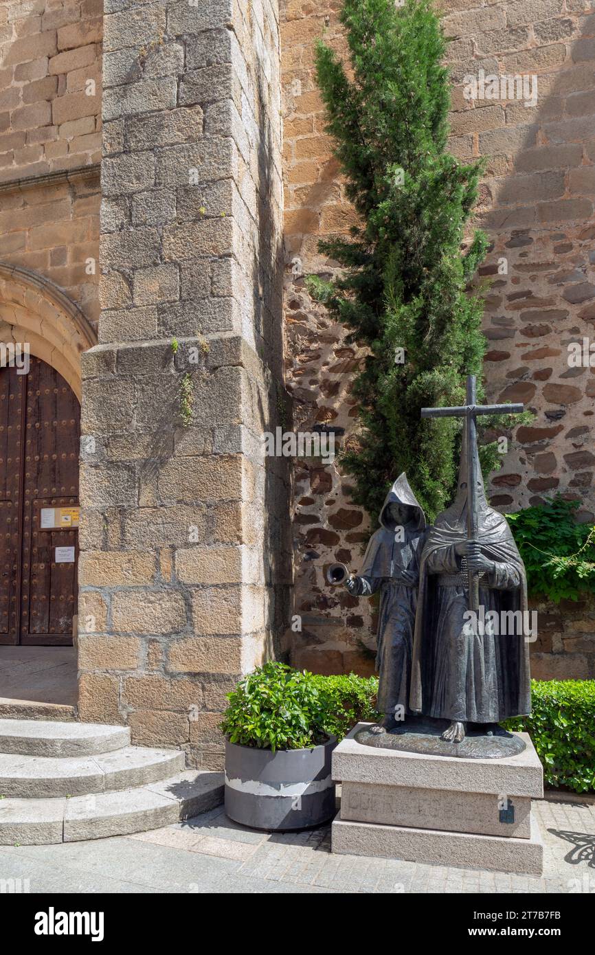 Europa, Spagna, Estremadura, Cáceres, Monumento a los Cofrades (Penitente o 'Nazareno' con cappuccio a punta 'Capirote') guidato da un monaco Foto Stock