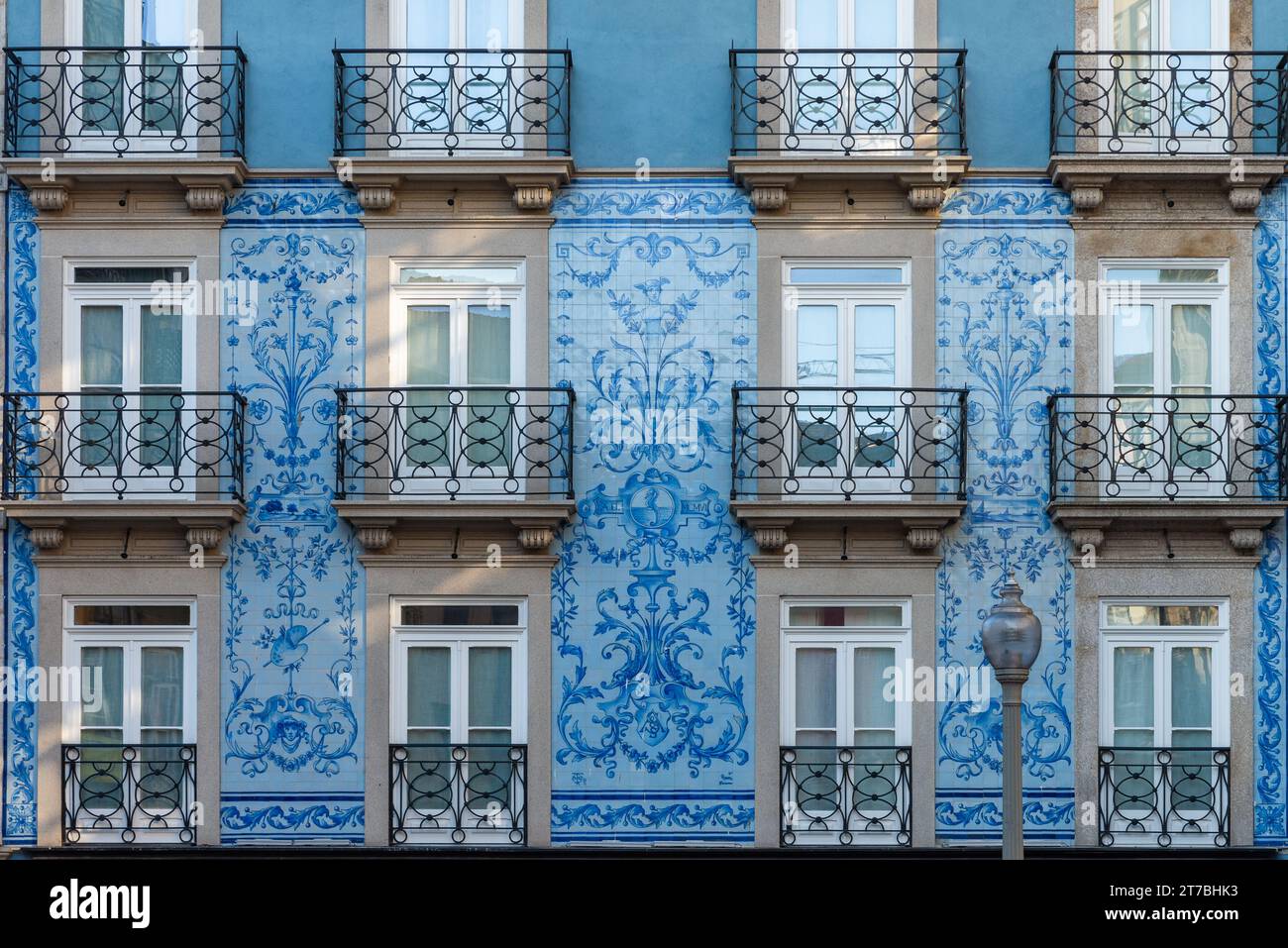Facciata dell'edificio con tipiche piastrelle portoghesi azulejos nella stretta strada medievale della città vecchia di Porto, Portogallo, con balcone e finestra. Medievale Foto Stock