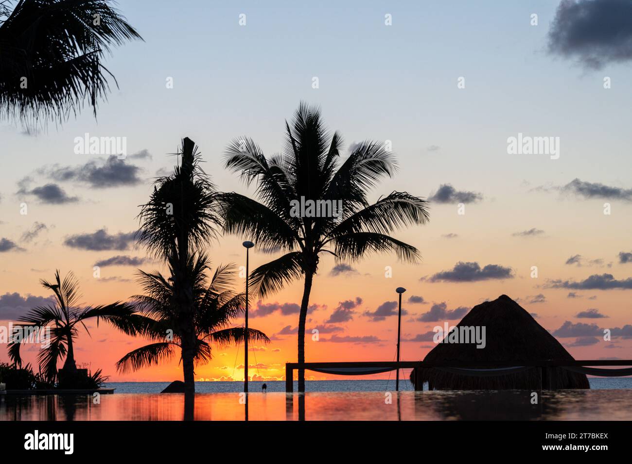 L'alba sul Golfo del Messico si riflette nella piscina a sfioro del resort Foto Stock