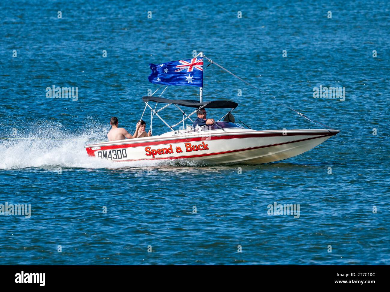 Un motoscafo con bandiera australiana che corre a tutta velocità in un lago. Queensland, Australia. Foto Stock