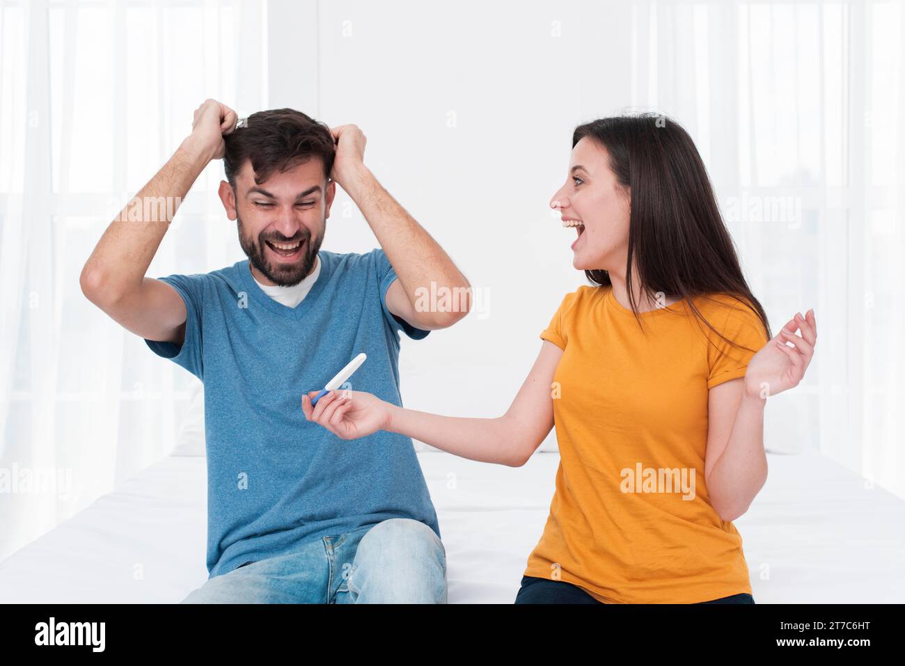 Coppia eccitata che tiene il test di gravidanza Foto Stock