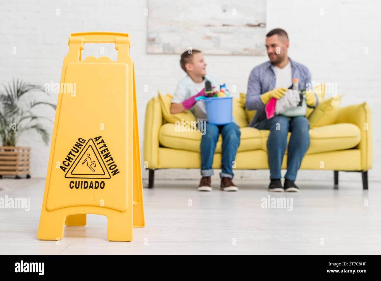 Cartello da pavimento bagnato con deconcentrato padre figlio Foto Stock