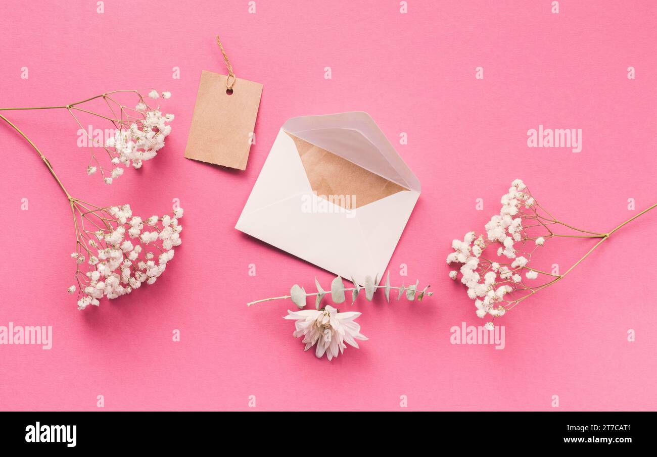 Rami di fiori con busta rosa tavolo Foto Stock