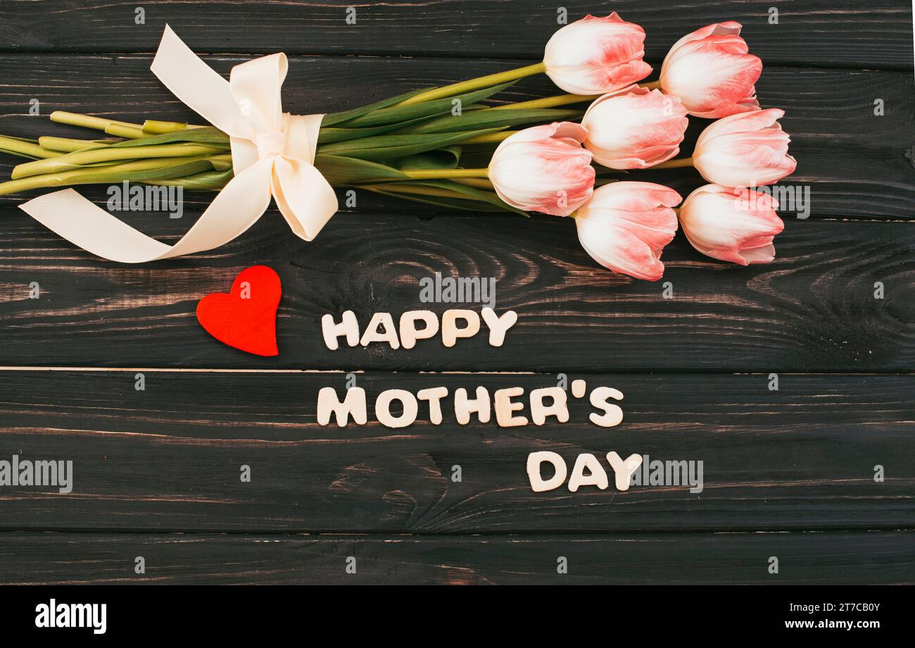 Felice iscrizione per la festa della mamma con tavolo bouquet di tulipani Foto Stock