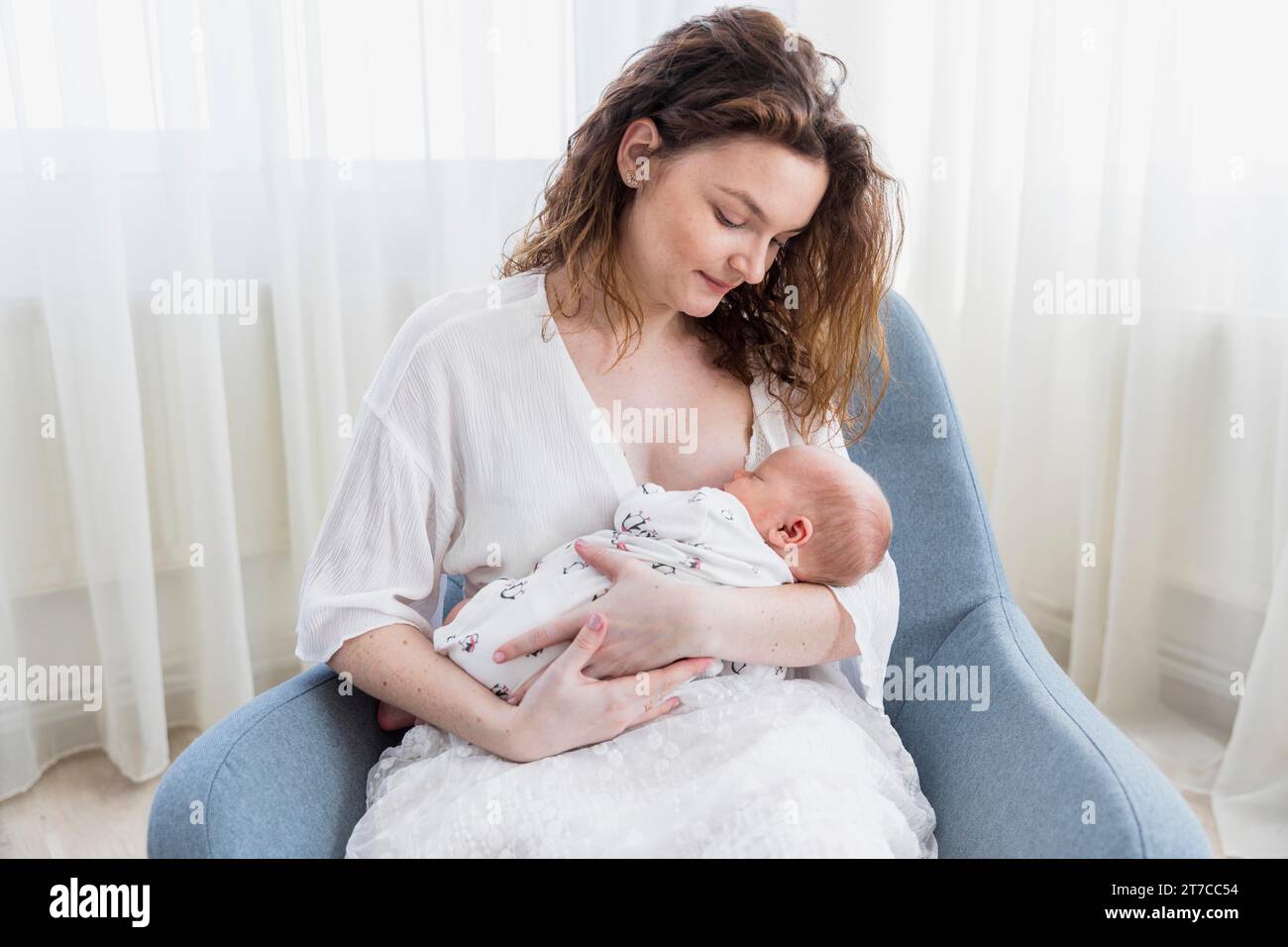 Madre sorridente con la sua poltrona da baby sitting Foto Stock