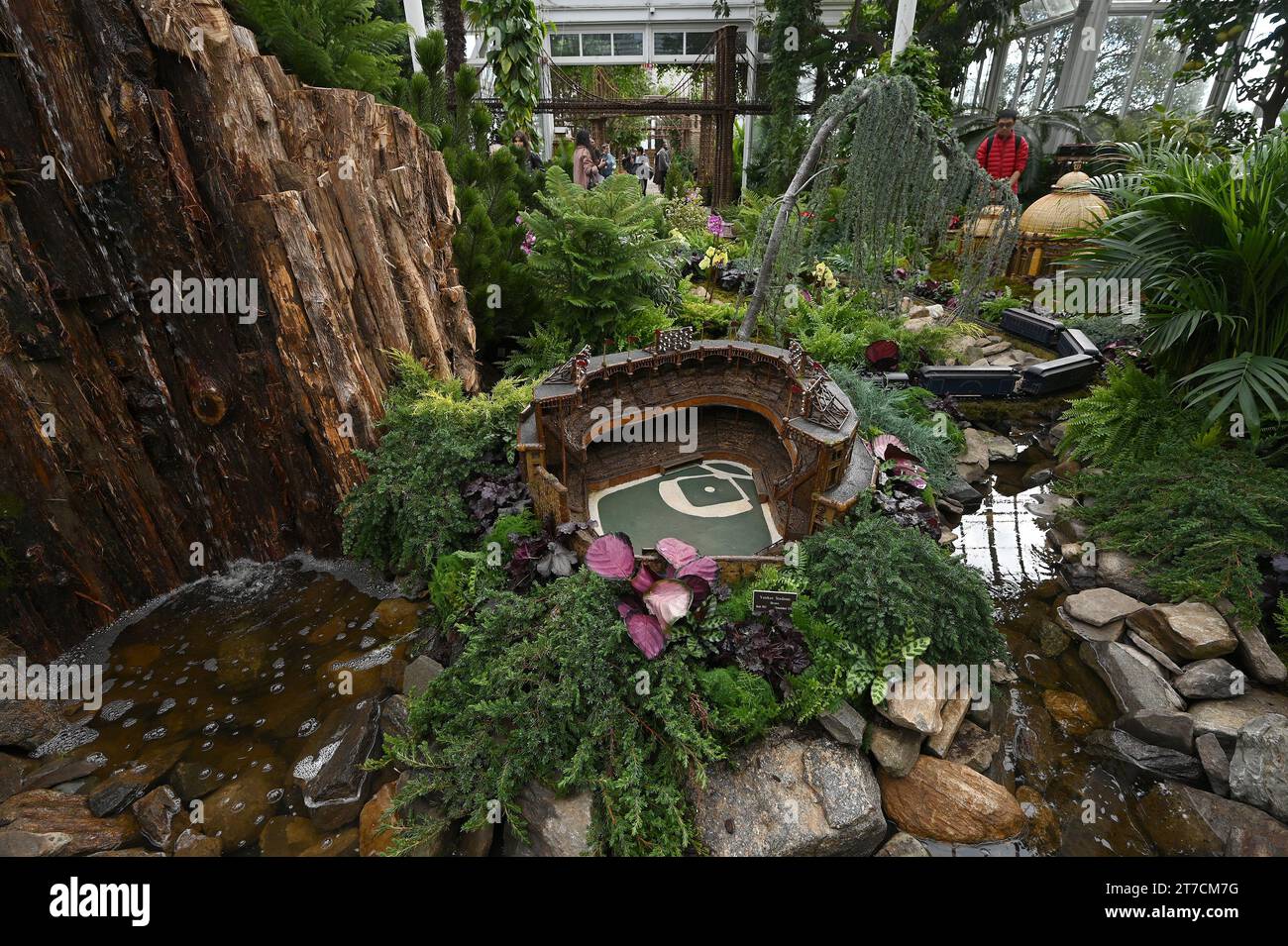 New York, USA. 14 novembre 2023. I modellini di treni elettrici percorrono le riproduzioni dei punti di riferimento di New York City al New York Botanical Garden Holiday Train Show durante il giorno dell'anteprima stampa, nel quartiere Bronx di New York City, NY, 14 novembre 2023. Edifici e strutture in miniatura sono costruiti con materiali naturali, tra cui legno, bastoni e piante, per creare punti di riferimento riconoscibili. (Foto di Anthony Behar/Sipa USA) credito: SIPA USA/Alamy Live News Foto Stock