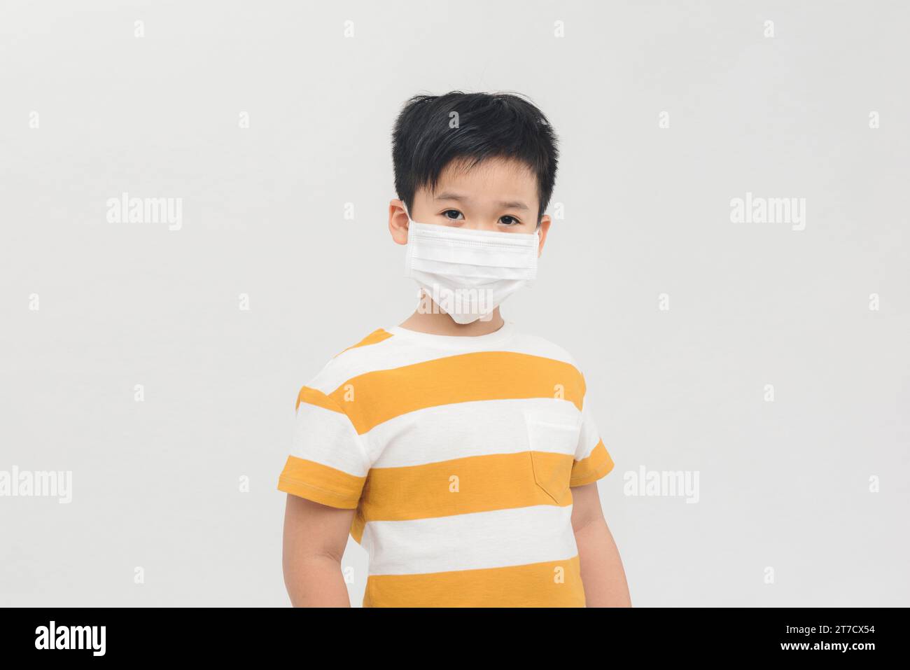 Giovane asiatico preteen ragazzo indossa maschera su sfondo bianco. Foto Stock