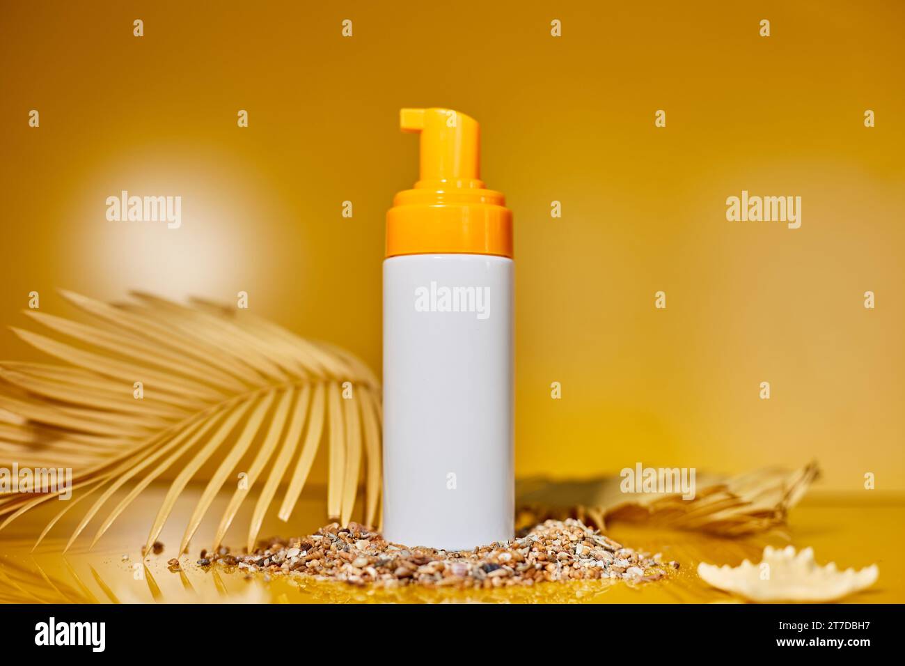 Tubo di protezione solare mockup con conchiglie, sfondo giallo sabbia, vacanze estive e spf uv-protezione della pelle concetto di cura, luce dura. Foto Stock