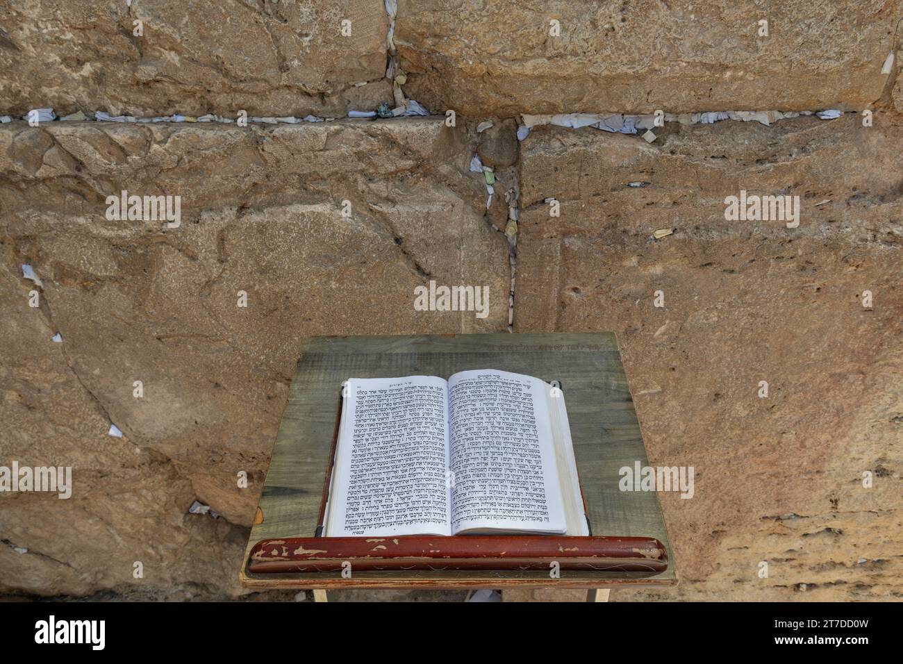 Un siddur o libro di preghiere ebraico è aperto al testo ebraico del canto dei canti su un piedistallo di fronte al muro Occidentale a Gerusalemme. Foto Stock