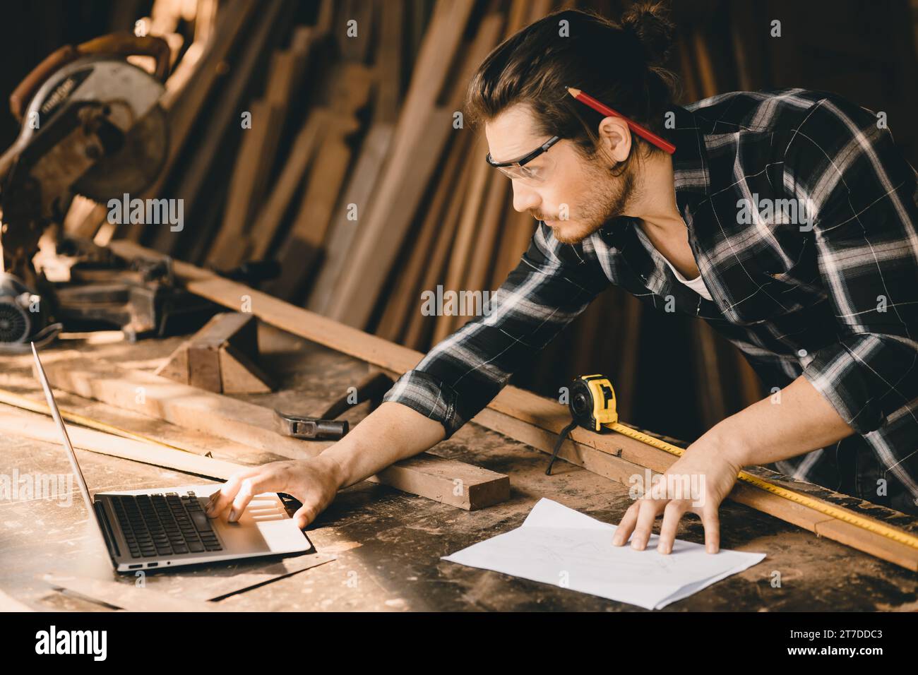 Carpenter man che utilizza software per computer portatili di tecnologia moderna ha aiutato a disegnare nuovi progetti di mobili in legno Foto Stock Carpenter man che utilizza software per computer portatili di tecnologia moderna ha aiutato a disegnare nuovi progetti di mobili in legno Foto Stock