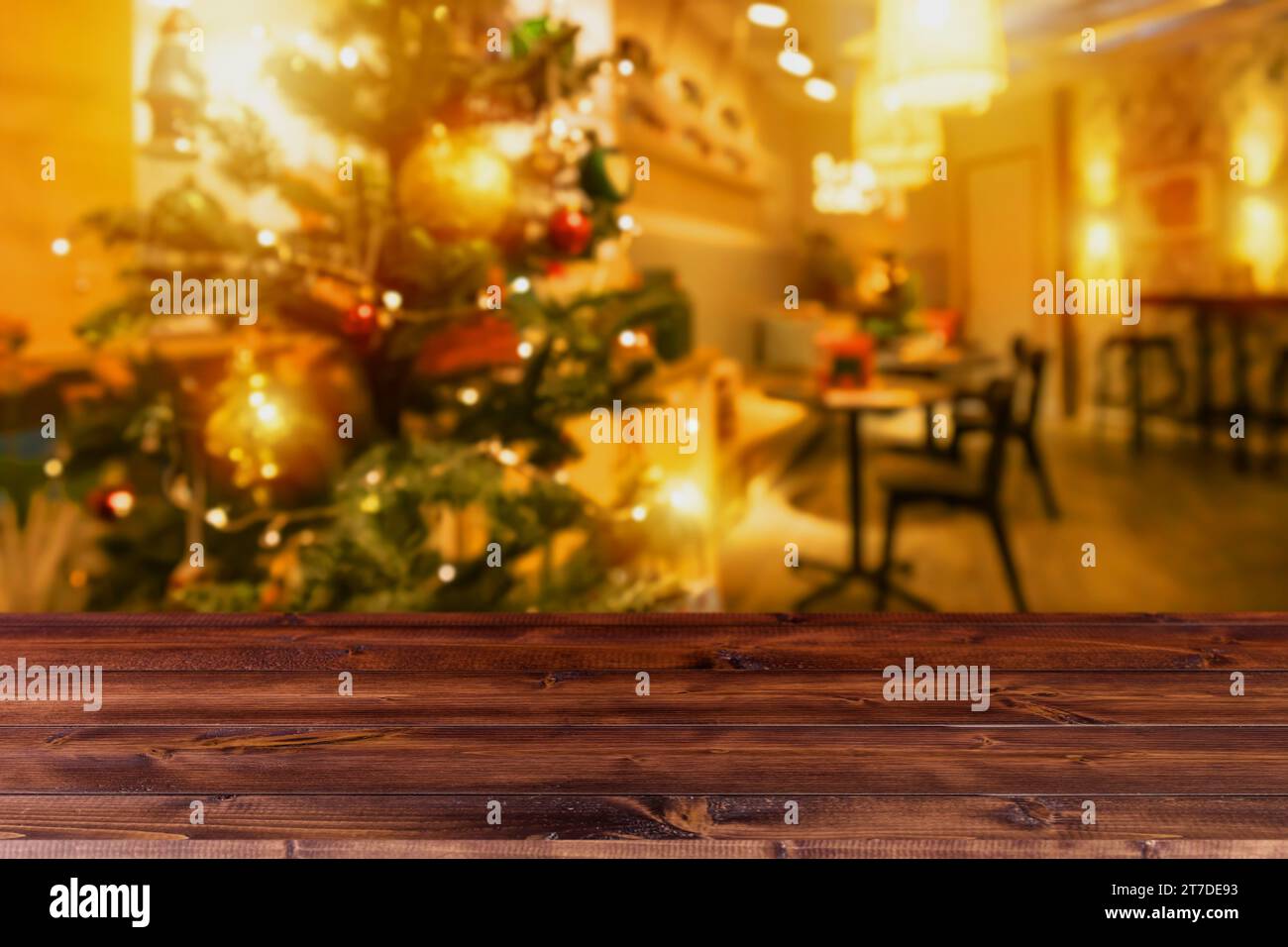 Sfocare gli interni della decorazione della casa natalizia con tavolo in legno, spazio vuoto per i prodotti da regalo, sfondo pubblicitario per montaggio. Foto Stock