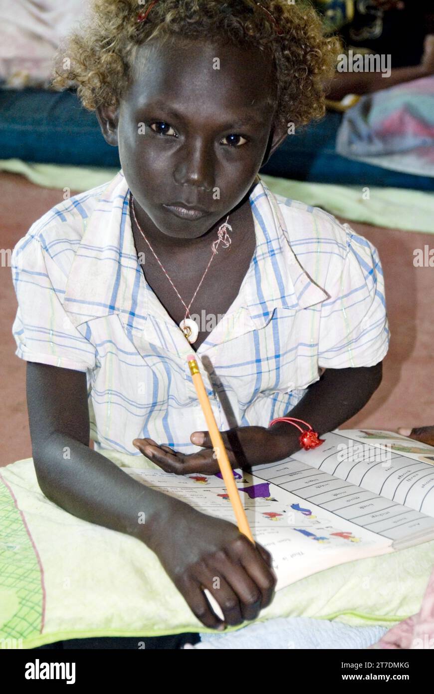 La giovane ragazza di Solomon Islander completa i compiti scolastici a bordo del M.S. Bikoi, un traghetto tra le isole Foto Stock