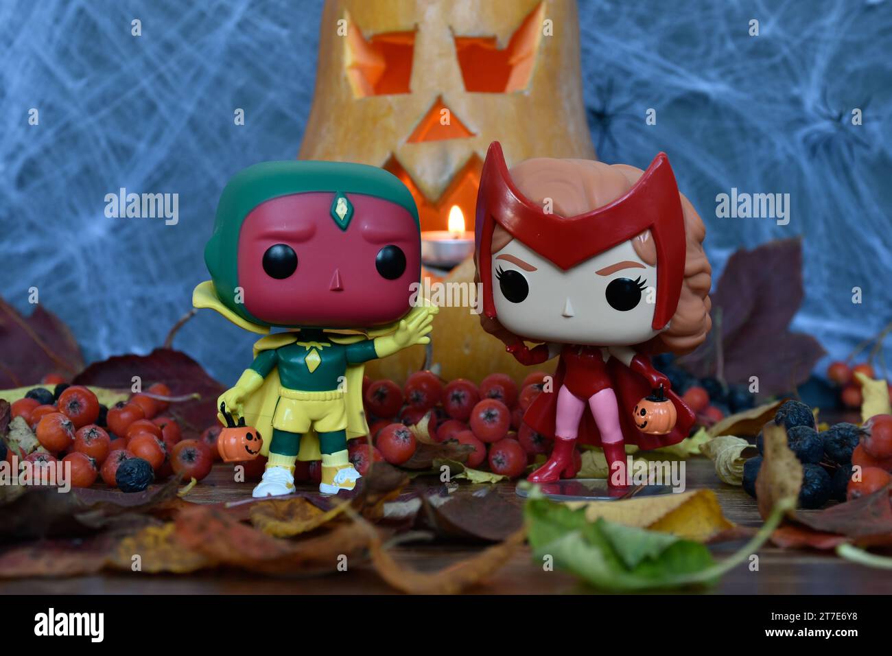 Funko Pop action figure dei supereroi Marvel Avengers Vision e Scarlet Witch Wanda in costumi di Halloween. Jack o lanterna, ragnatela, foglie cadenti. Foto Stock