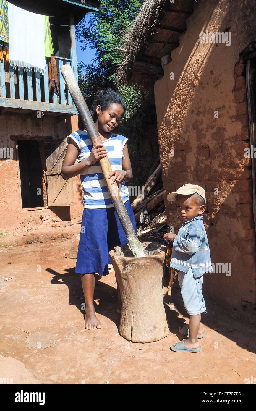 Madagascar, Village proche Antsirabe, femme et son enfant préparation du mais Hautes Terres, sur la RN7 Foto Stock