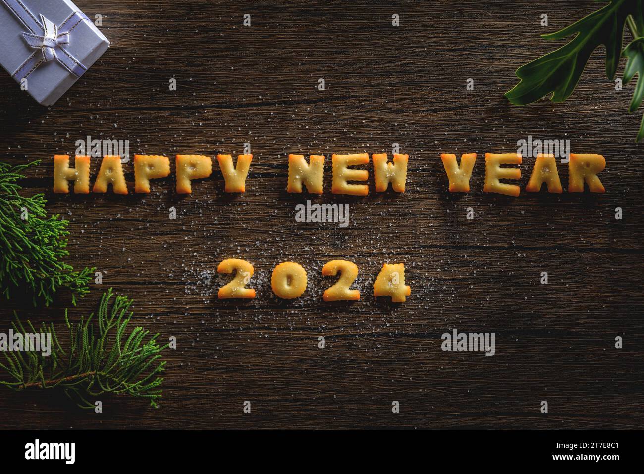 2024, l'anno 2024 scritto in lettere di pane su uno sfondo di motivi di legno. Foto Stock