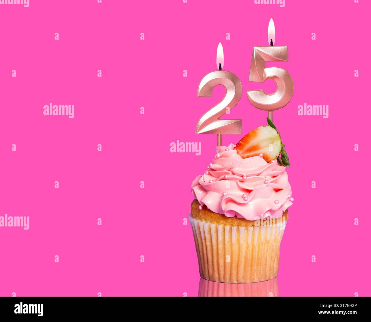 Torta di compleanno con candela numero 25 - su sfondo rosa caldo. Foto Stock