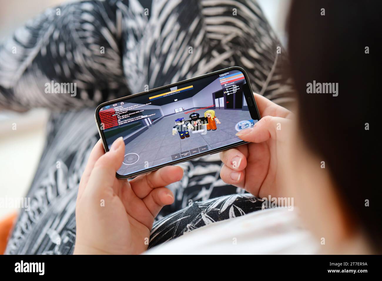 Roblox per dispositivi mobili iOS, gioco sullo schermo dello smartphone iPhone 15 in mani femminili durante l'azione di gioco mobile. Giochi e intrattenimento mobili su dispositivi portatili Foto Stock
