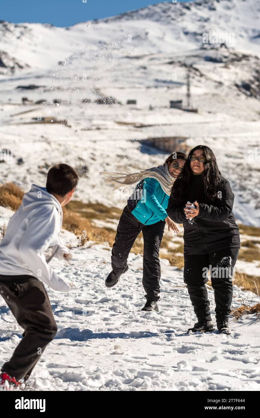 gente latina sulle montagne innevate della sierra nevada a granada, giocando con la neve in una giornata di sole, andalusia, spagna Foto Stock