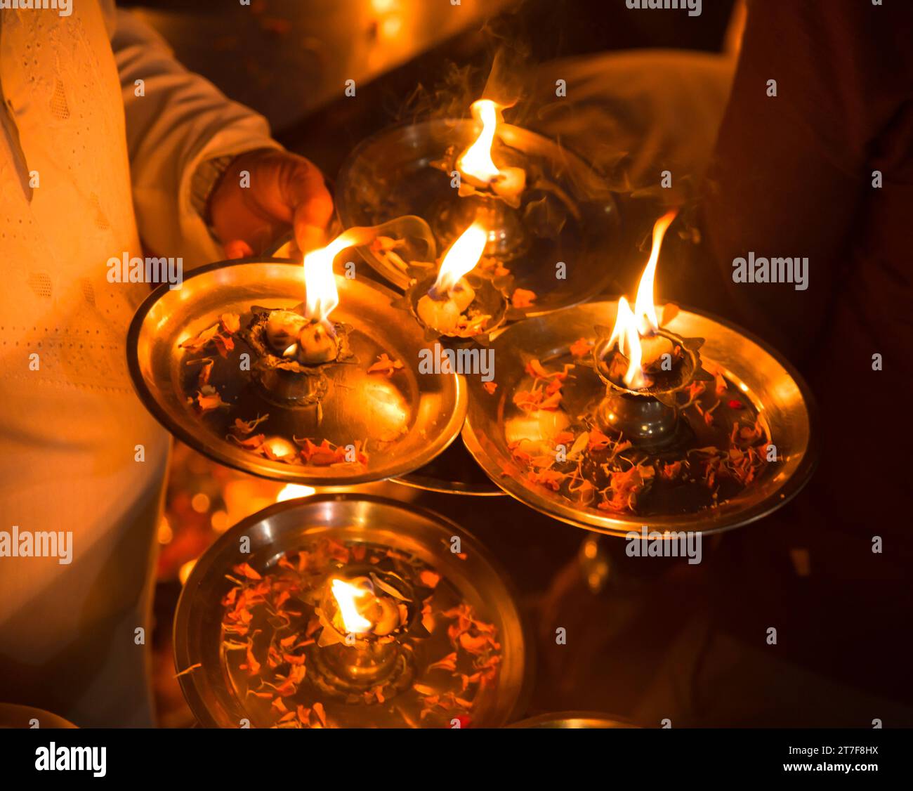 Una mano di un uomo che tiene 4 lampade a diya a olio a ganga aarti a Rishikesh Foto Stock