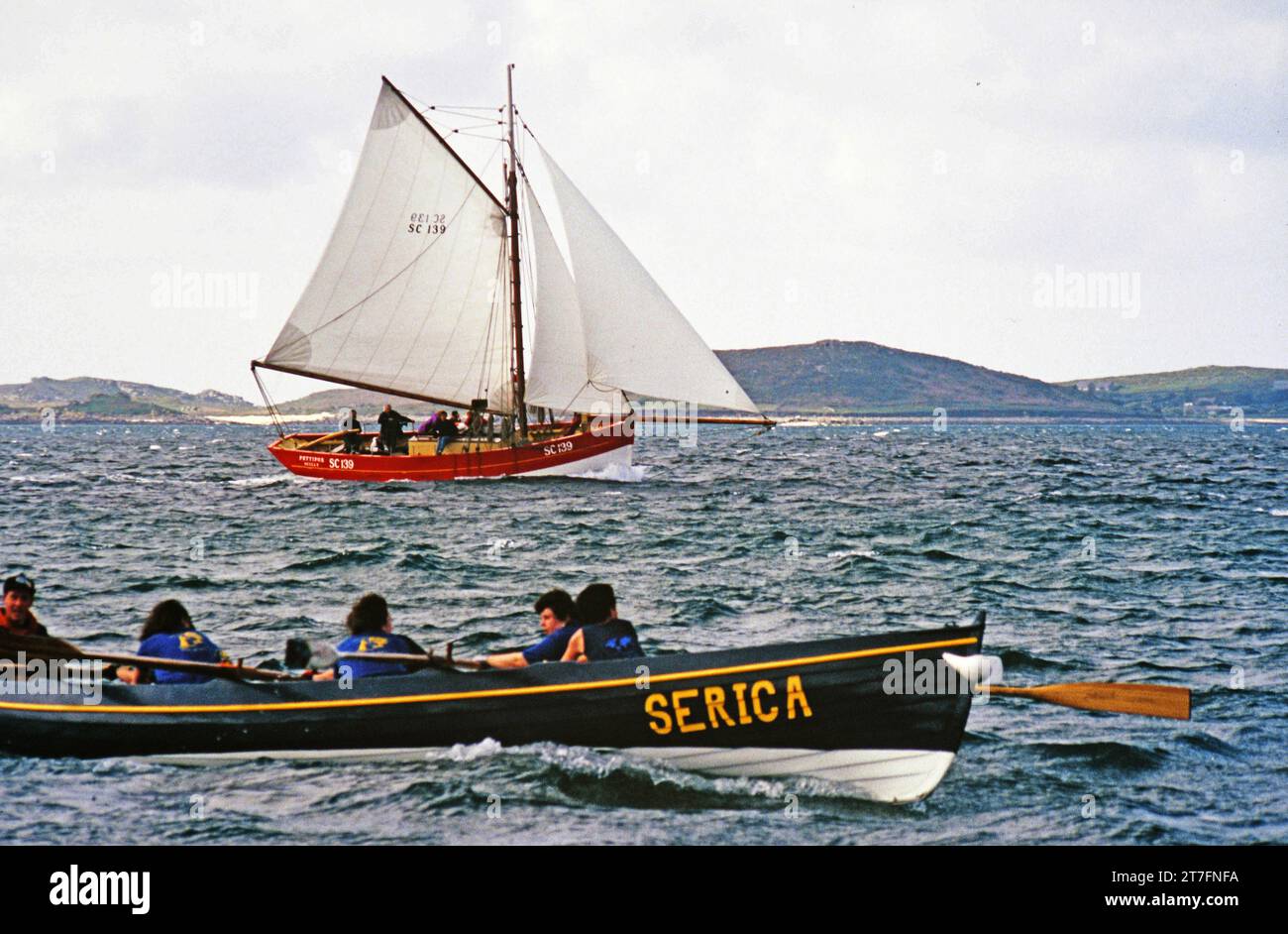 Pettifox, una replica di granchi francesi, l'ultima barca a vela in legno costruita sulle isole Scilly, vista qui a seguito di una delle barche in una gara femminile Foto Stock