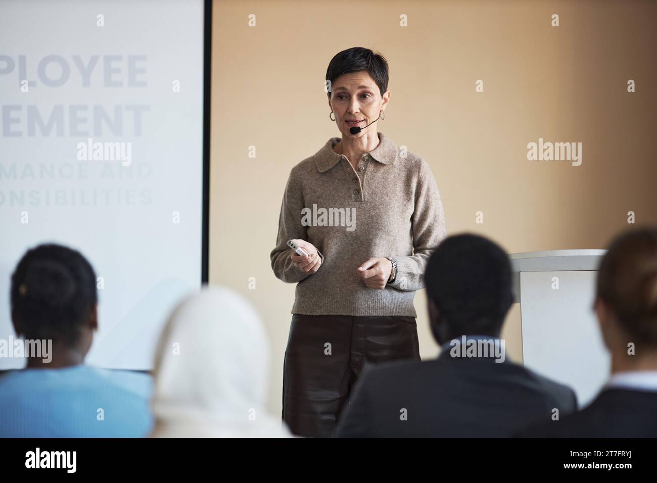 Una posizione professionale sicura di fronte al pubblico durante la presentazione dei principi di impiego e la spiegazione di uno dei punti Foto Stock
