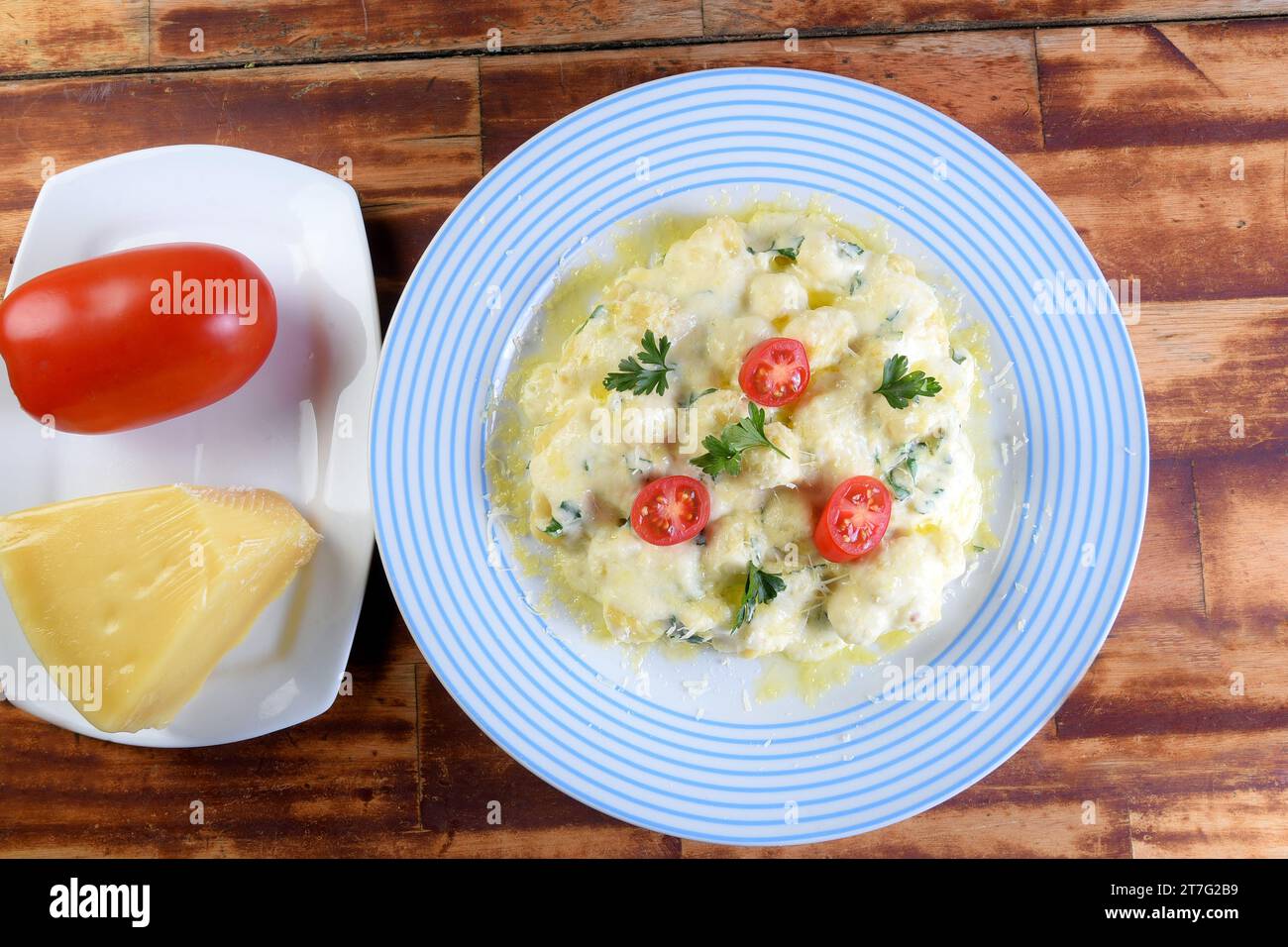 piatto di pasta e gnocchi in salsa di béchamel con olio di pomodoro, immagine viata dall'alto con spazio per il testo Foto Stock