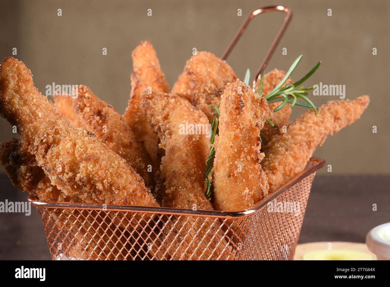 porzione di pesce fritto, strisce di pollo fritte all'interno del cestino di metallo, gustoso spuntino Foto Stock