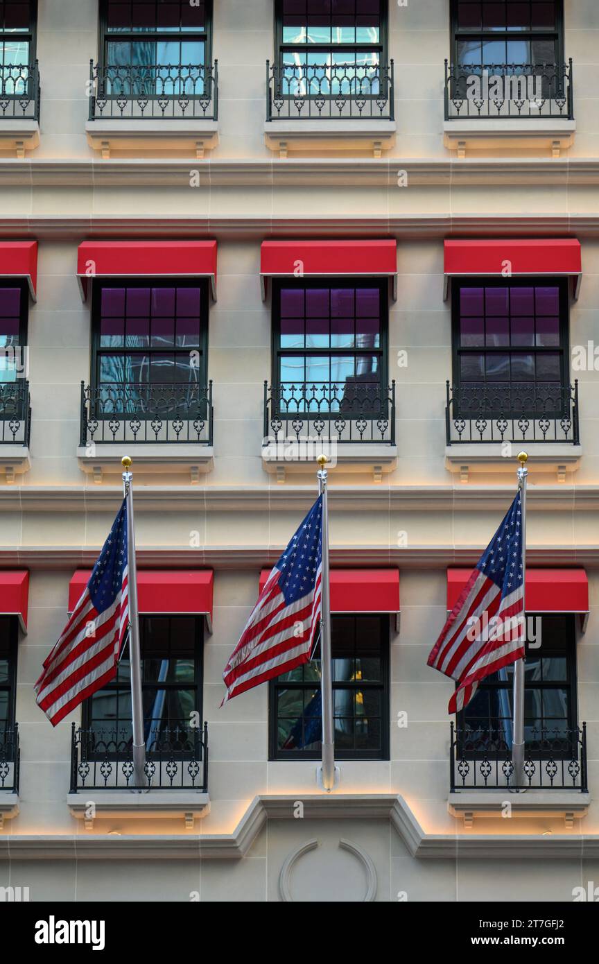 Bandiere americane che volano su un New York Retail Building sulla 5th Avenue Foto Stock