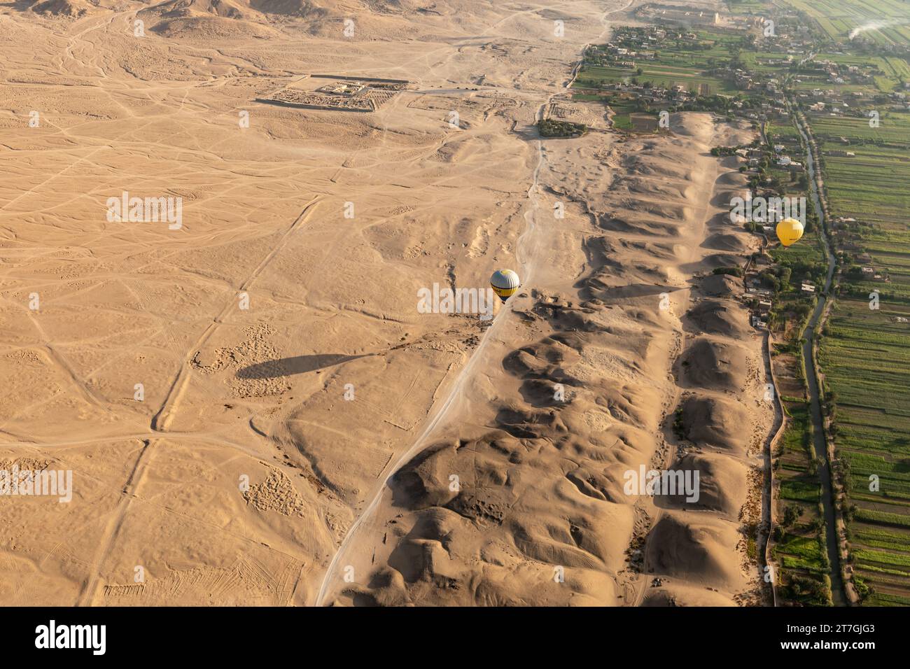 Vista aerea della mongolfiera su una fila di antiche tombe piramidali ai margini del deserto e dei fertili campi della valle del Nilo Foto Stock