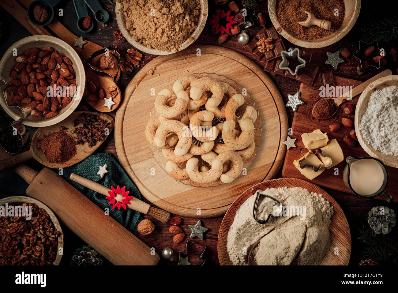 Piatti con croissant al caffè, ingredienti da forno, decorazioni natalizie, farina, zucchero, mandorle, noci, cannella, taglierine per biscotti Foto Stock