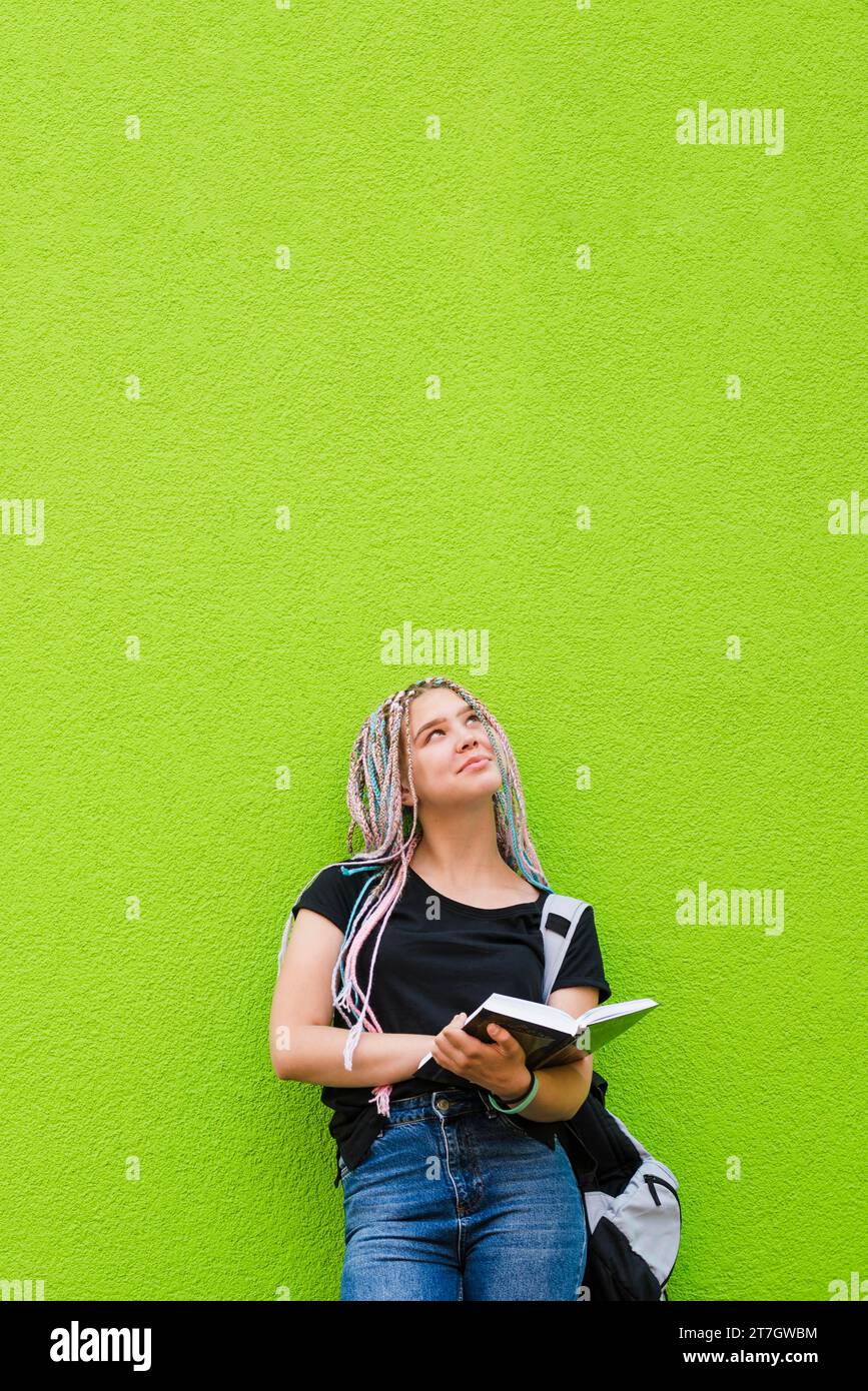 Giovane ragazza allegra con un libro di testo Foto Stock