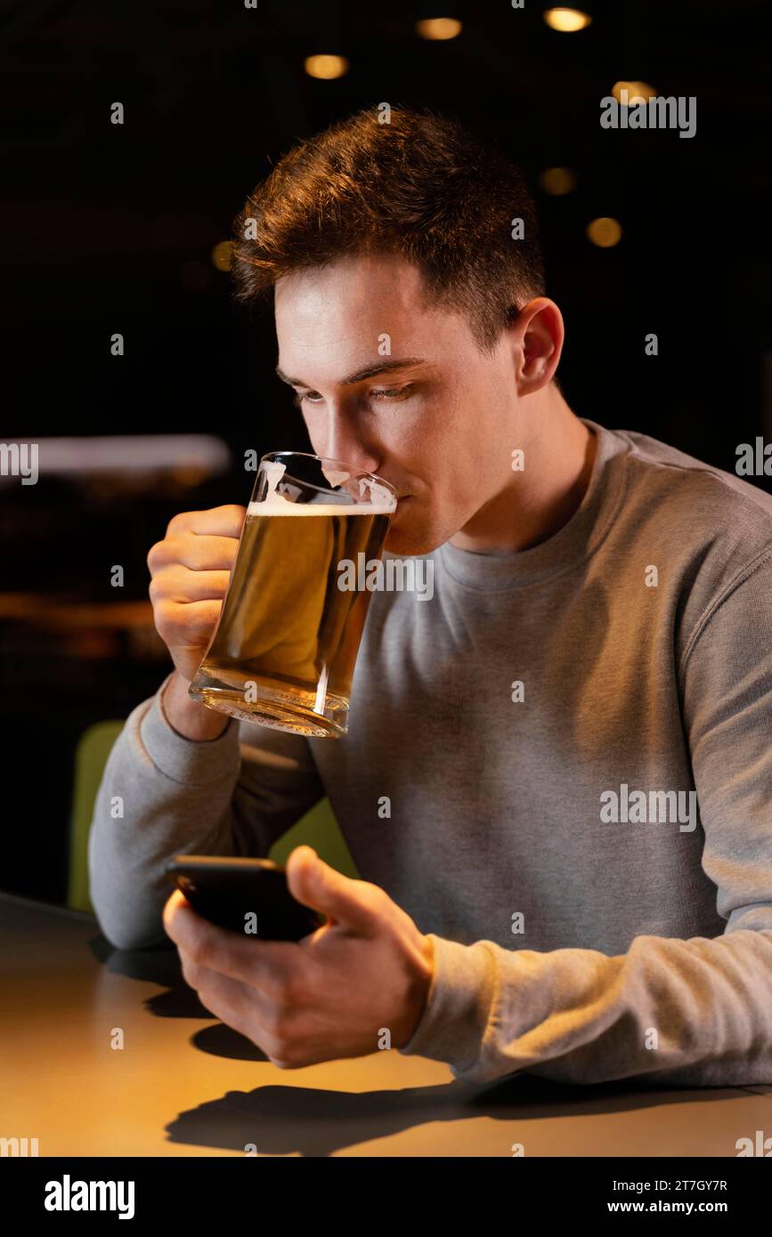 Un uomo medio che beve birra pub Foto Stock