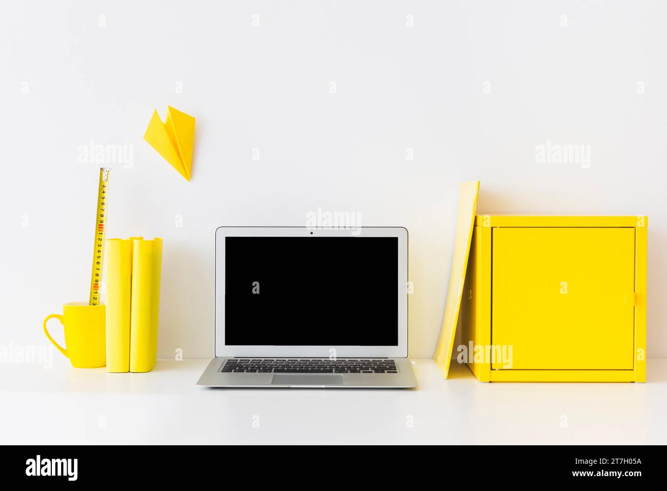 Spazio di lavoro elegante con scatola metallica gialla per laptop Foto Stock