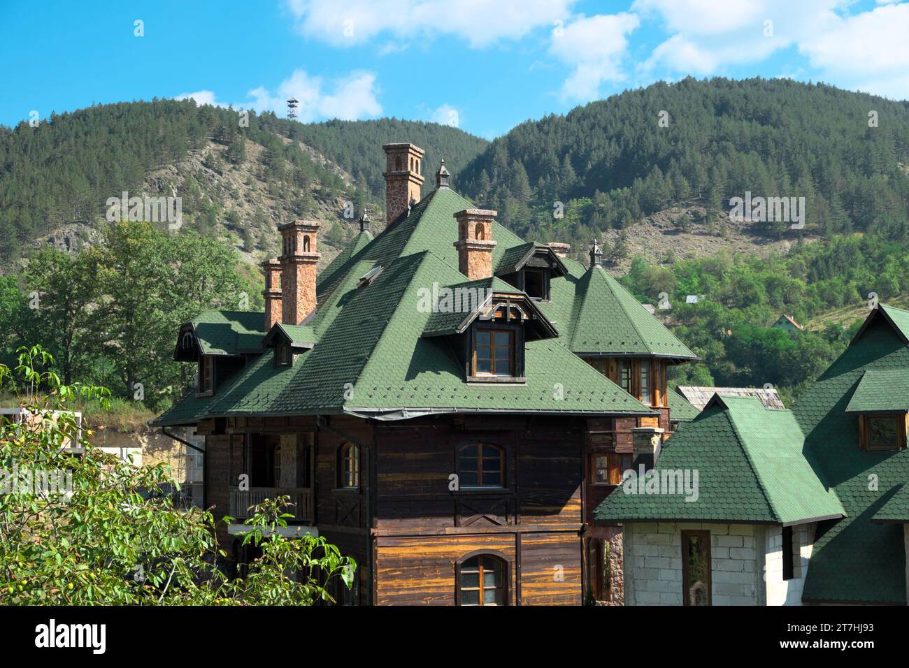 Tetto con finestre dormitori e camini di casa di montagna a Mokra Gora, Serbia Foto Stock
