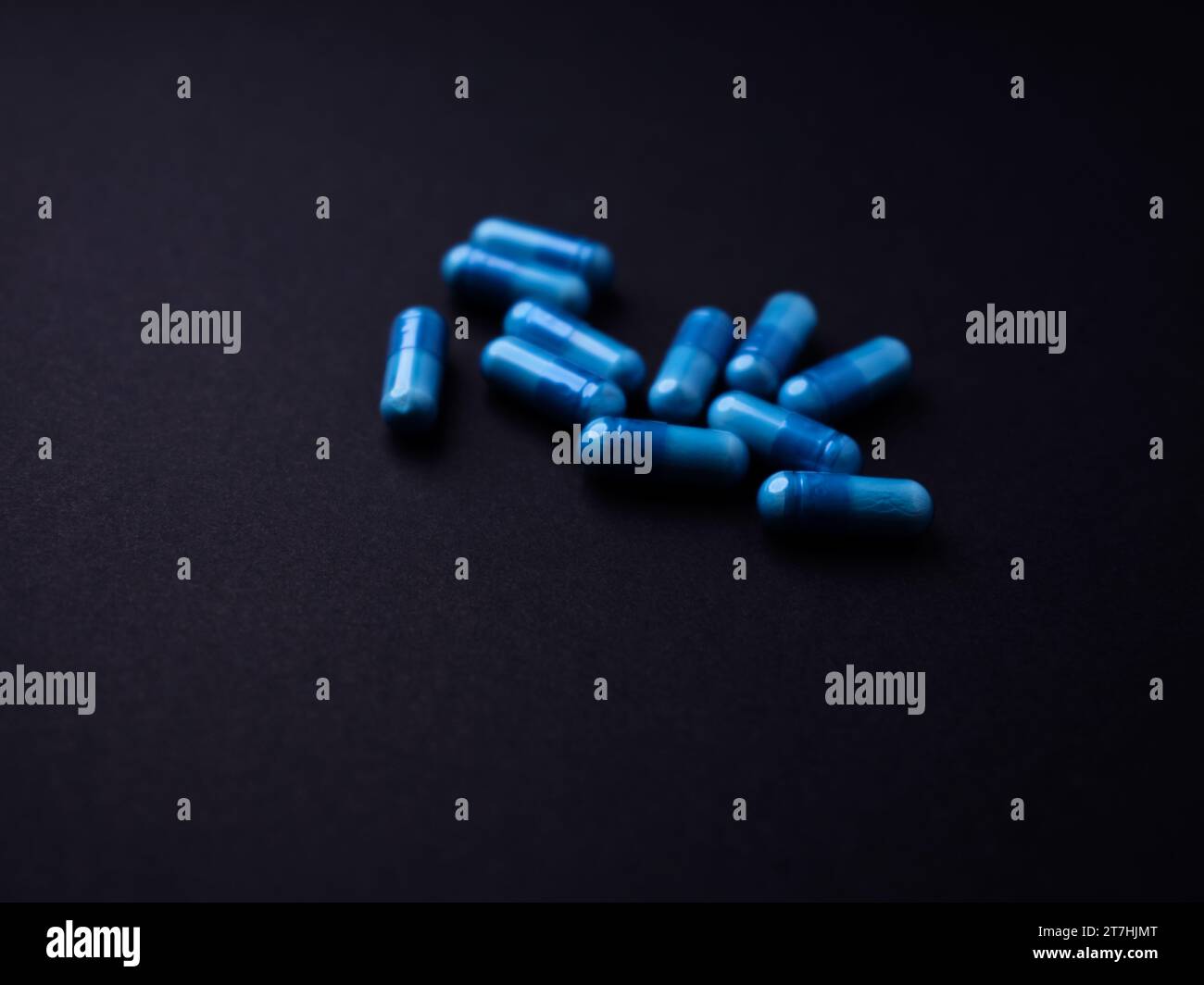 Capsule di aminoacidi su sfondo di carta scura. Messa a fuoco morbida. Primo piano. Copia spazio. Foto Stock