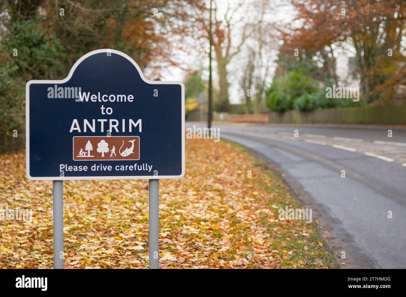 Cartello Benvenuti a Antrim, si prega di guidare con prudenza, con foglie di autunno Foto Stock