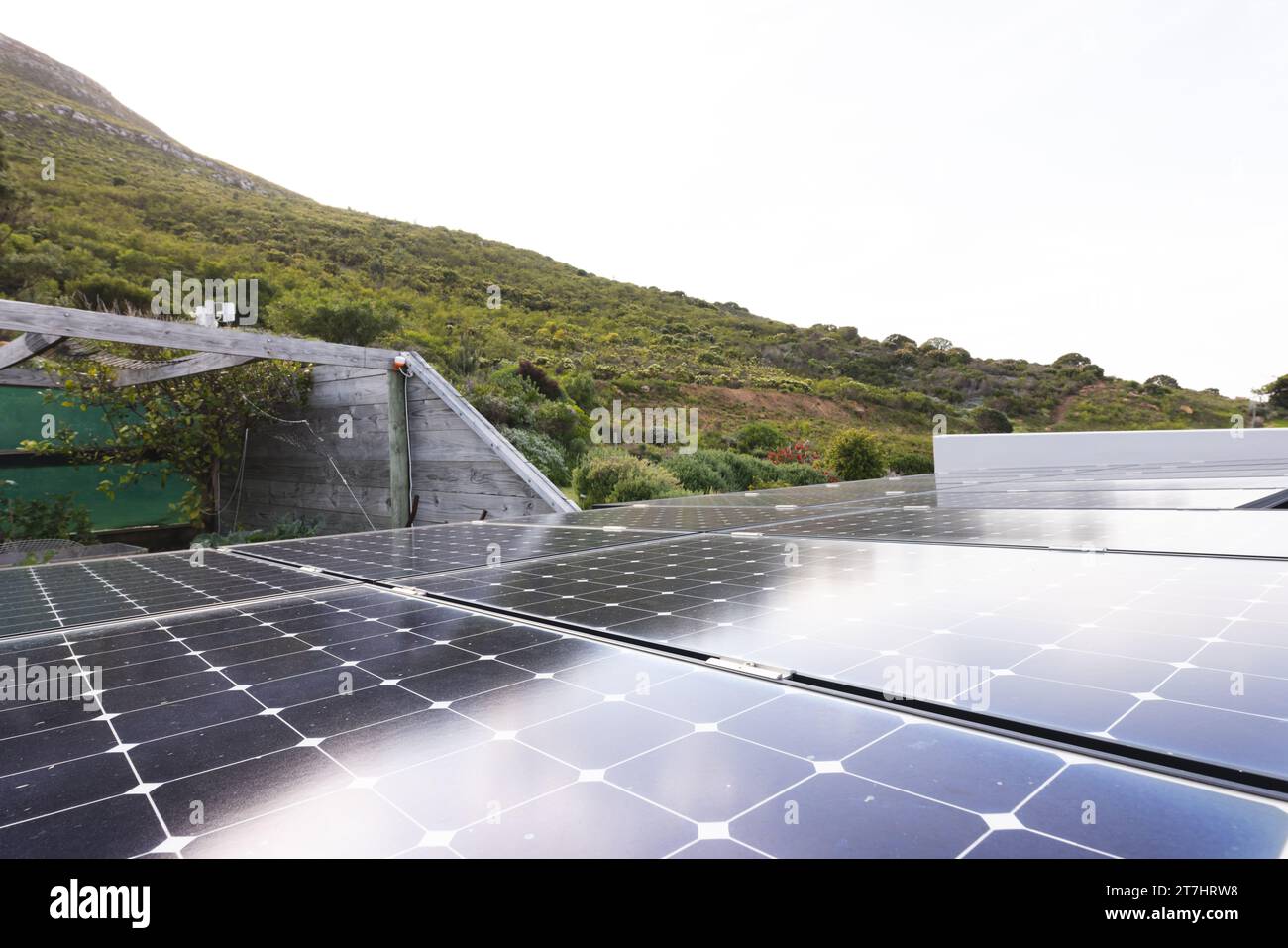 Primo piano dei pannelli solari sul tetto della casa vicino alla collina nelle giornate di sole, spazio fotocopie Foto Stock