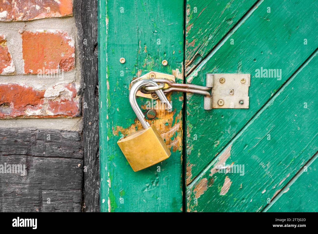 Aprire la serratura su una porta verde rustica del fienile. Foto Stock