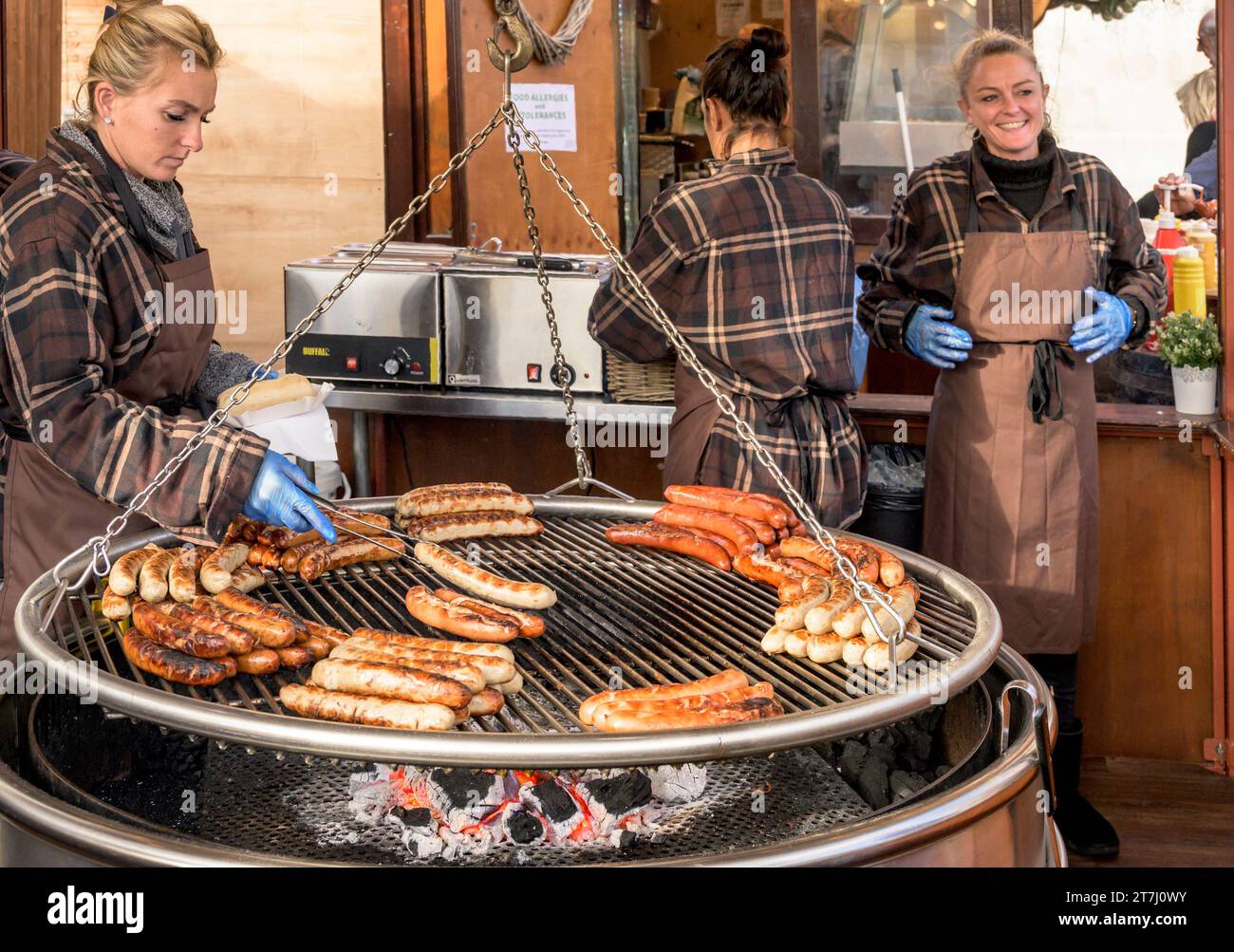 Londra, Regno Unito. Salsicce tedesche cucinate a Trafalgar Square dalla German Sausage Company, nel mercatino di Natale di fronte alla National Gallery, Foto Stock