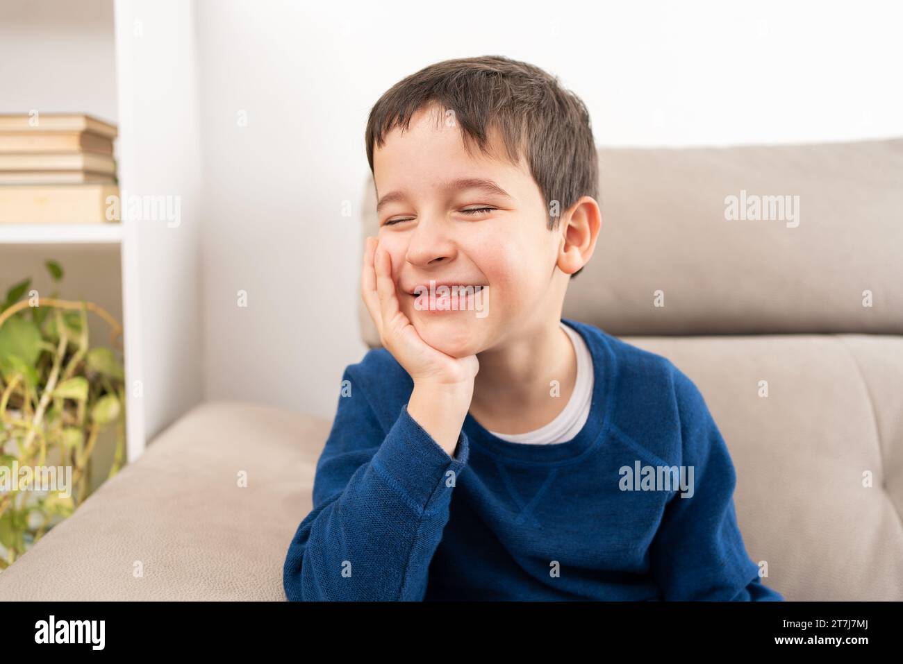 Le sue menti in un altro posto completamente. Un bambino che sogna ad occhi aperti a casa Foto Stock