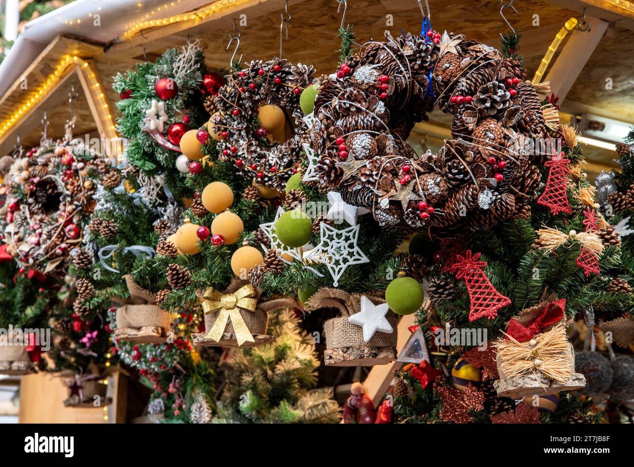 L'incantevole angolo del mercato di Santa Llucia: Una bancarella piena di squisite ghirlande natalizie, che aggiunge fascino festivo allo spirito natalizio di Barcellona Foto Stock