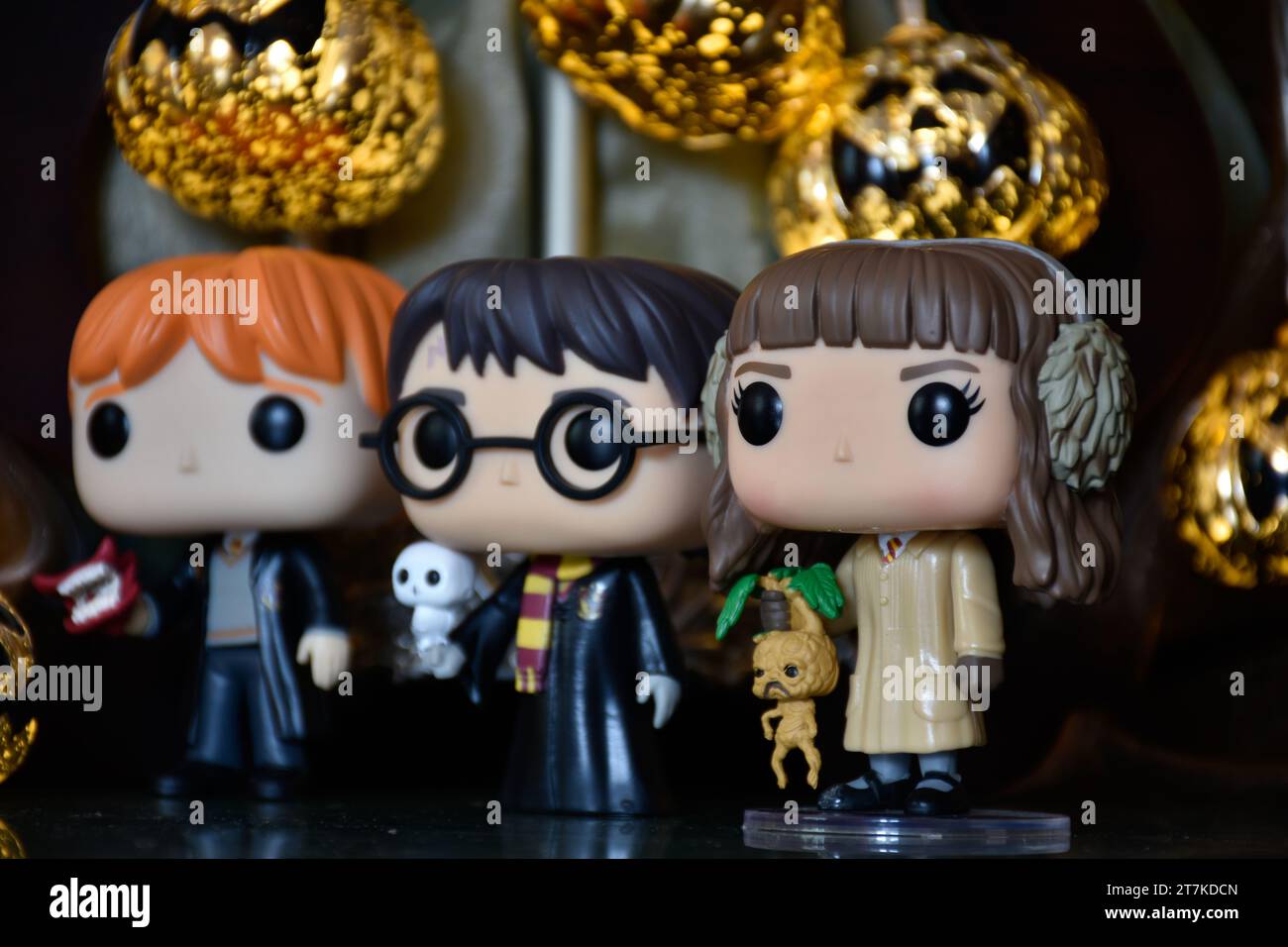 Funko Pop action figure di Ron Weasley, Harry Potter e Hermione Granger. Luci di zucca di Halloween, palazzo oscuro, misterioso, magico, stagione spettrale. Foto Stock