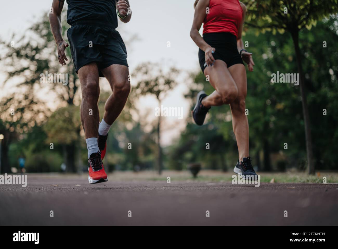 Coppia attiva che si diverte a fare jogging serale nel parco. Foto Stock